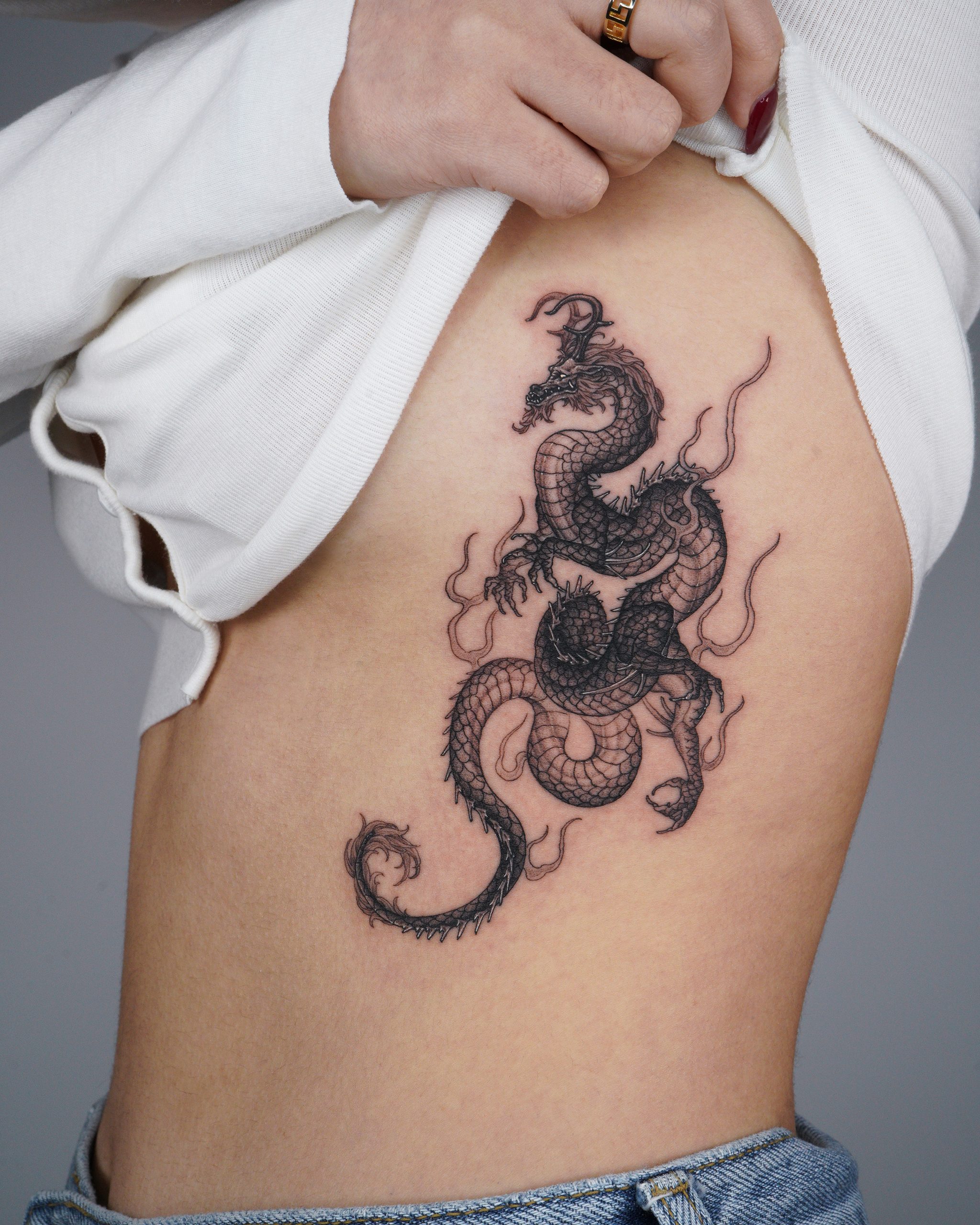 A detailed shot of a blue/green dragon tattoo in Japanese style on the  forearm, elbow and bicep of a white male isolated on a black background. -  Stock Image - Everypixel