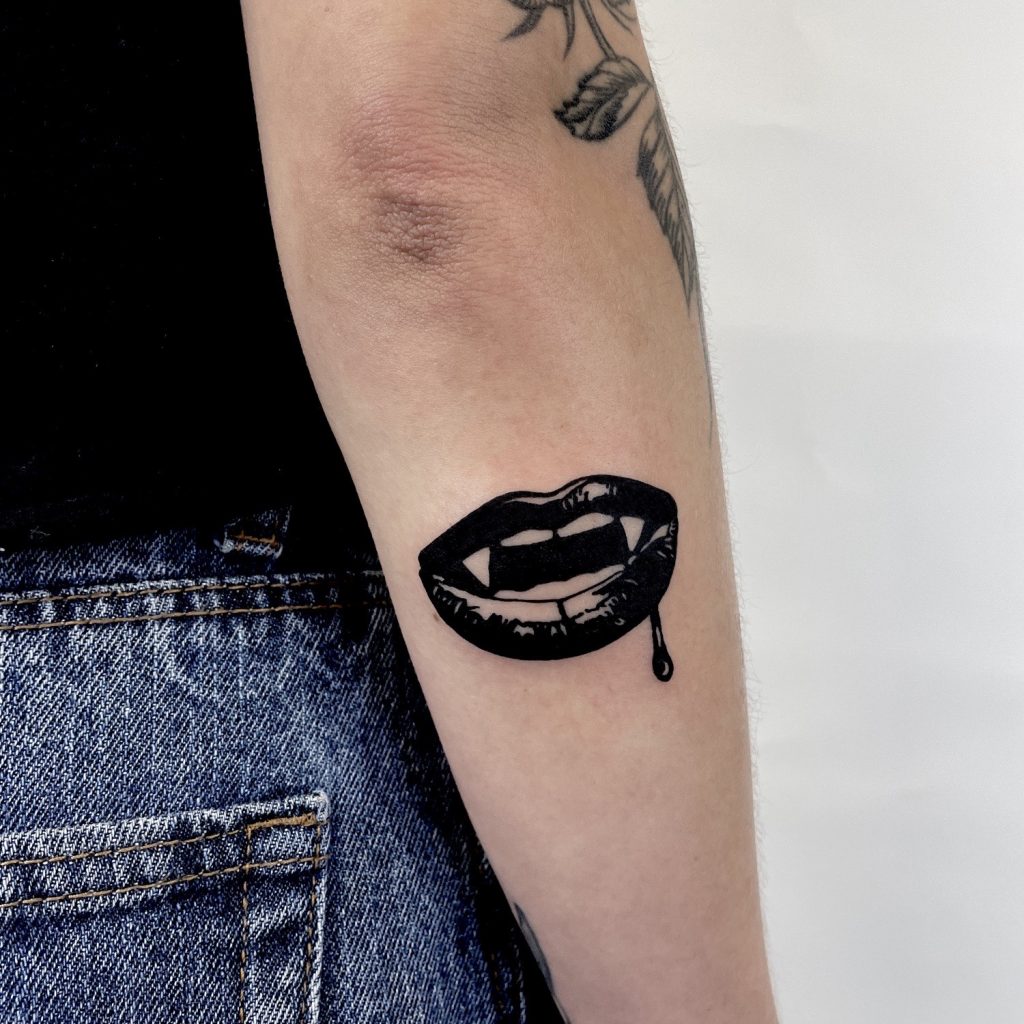 Black lips with fangs tattoo
