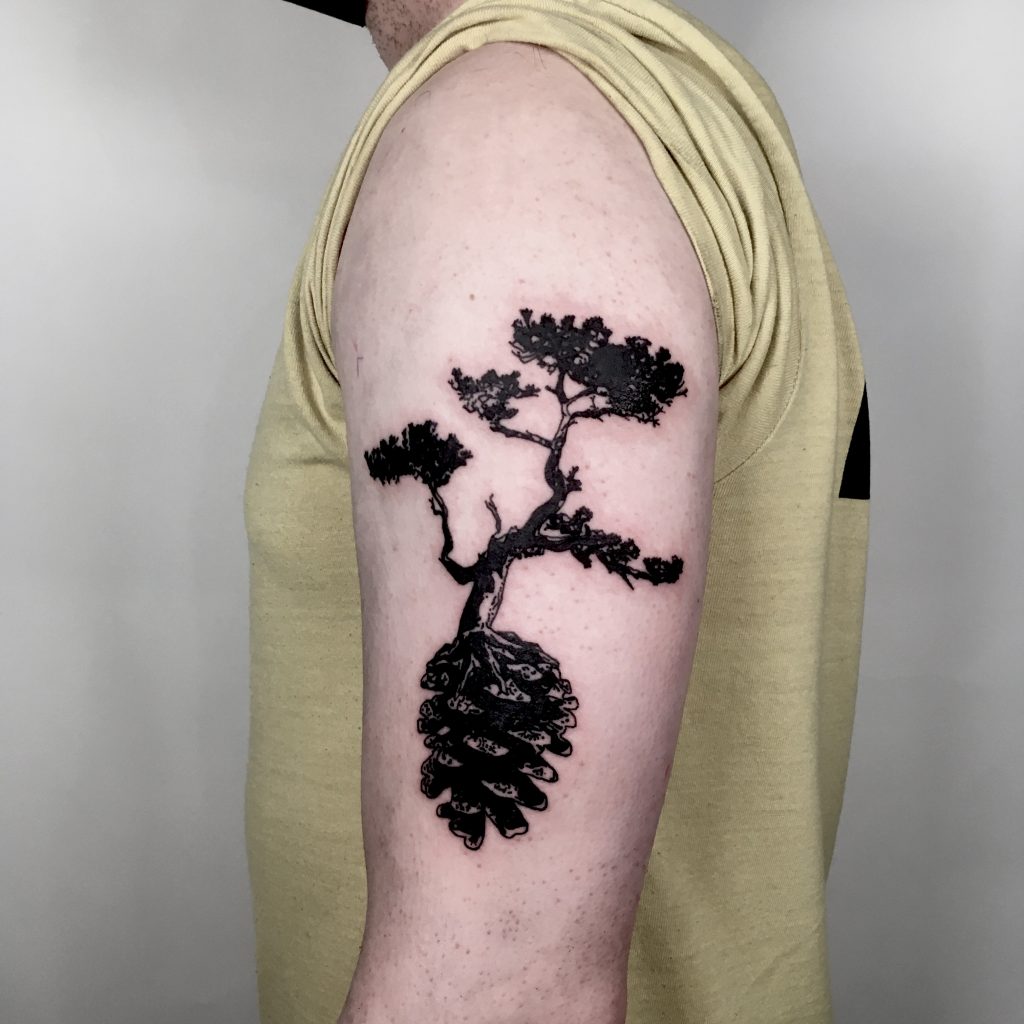 Black tree growing on a pinecone tattoo
