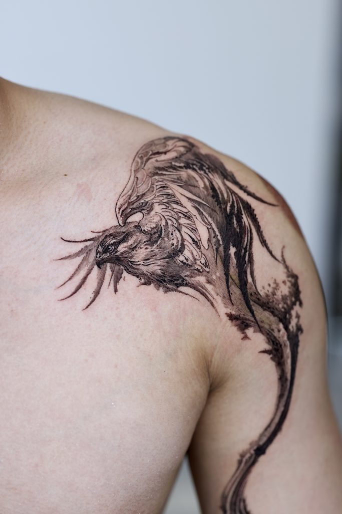 Black abstract eagle tattoo on shoulder