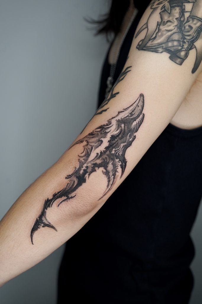 Blackwork abstract shark tattoo on upper arm