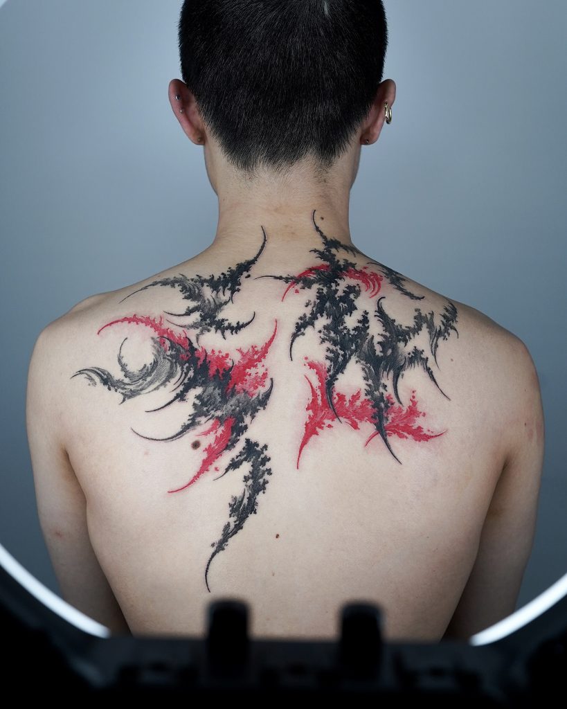 Black and red abstract tattoo on back